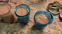 three jars filled with chocolate pudding sitting on top of a counter next to other containers