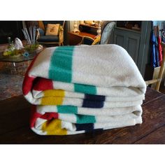 stack of multicolored towels sitting on top of a wooden table