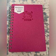 a pink notebook with hello kitty on it