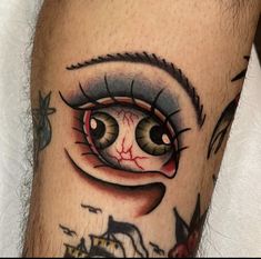 a close up of a person's leg with a tattoo on it and an eye