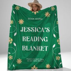 a woman in a hat is holding a green book cover that reads jessica's reading blanket