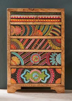 an intricately painted wooden box with drawers