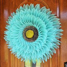 a large blue flower is hanging on the front door