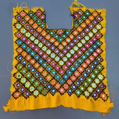 a piece of cloth that has been stitched together and is yellow with multicolored flowers on it