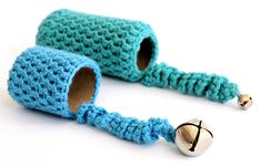 two blue crocheted objects with bells on them