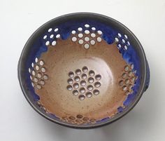 a blue and brown bowl sitting on top of a white table