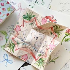 several folded cards with flowers on them and some calligraphy in the middle one is for someone to write