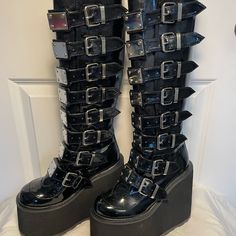 Demonia Knee-High Boots With Lots Of Buckles & Hardware. New In Box, Never Worn. Great Stacks For Long Hours Of Rocking Out. Back Zipper. Platform Heel = 5.5", Front Platform = 3", Boot Shaft ~15", Calf Circumference = ~13" But Is Adjustable With Buckles. #Goth #Halloween #Stacks #Gogo #Punk #Rocker Shoes Demonia, Knee High Platform Boots, Goth Halloween, Demonia Shoes, Black Platform Boots, Gogo Boots, Punk Rocker, Long Hours, Black Platform