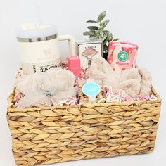 a basket filled with lots of items on top of a white table next to a cup