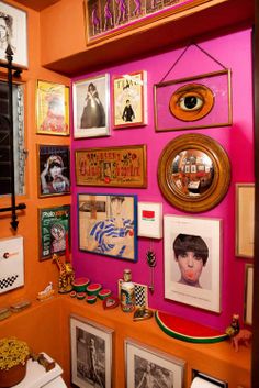 a bathroom with pink walls and pictures on the wall