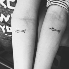 two people with matching tattoos on their arms, one has an arrow and the other has a long tail