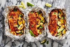 three foil packets filled with food on top of a marble counter