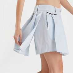 Our pleated kilted short in a cloud cotton print will lift your spirits to the sky this summer. A fusion of style and functionality, the pleated panel gives the appearance of a mini skirt with the unexpected surprise of shorts below. A side flap pocket adorned with a small horn button adds a touch of artisanal charm. The inclusion of a side zipper ensures ease of wear, complemented by the elastic band at the back of the waist for added comfort and convenience. Crafted from premium cotton these p Summer Mini Pleated Skirt With Built-in Shorts, Fitted Accordion Pleated Shorts For Summer, Blue Pleated Hem Bottoms For Summer, Blue Pleated Hem Summer Bottoms, Summer Blue Bottoms With Pleated Hem, Summer Skort With Accordion Pleats And Short Length, Short Cotton Pleated Skirt, Spring Bottoms With Accordion Pleats And Short Length, Summer Cotton Skort With Pleated Hem