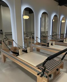 a row of benches sitting next to each other in a room with mirrors on the wall