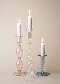 three glass candlesticks sitting next to each other