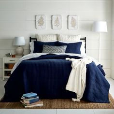 a bedroom with white walls and blue bedding