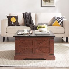 a living room with a couch, coffee table and pictures on the wall above it