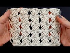 two hands holding up a white crocheted square