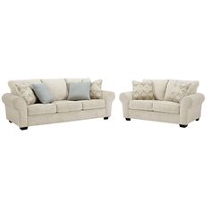 two couches with pillows on them sitting side by side in front of each other