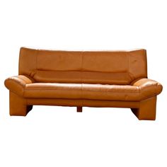 a brown leather couch sitting on top of a white floor