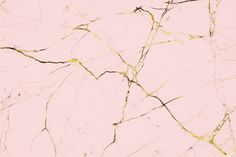 a pink and gold marble textured wallpaper with black lines on the bottom right corner