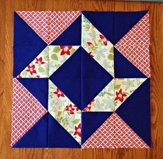 a blue and white quilted block on a wooden floor