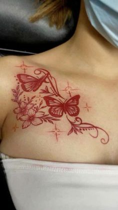 a woman's chest with a butterfly tattoo on it and flowers around the neck