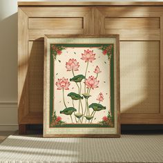 a painting with pink flowers and green leaves on the side of a wooden cabinet next to a window