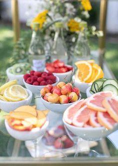 a table topped with bowls filled with different types of fruit