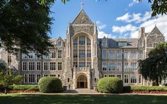 a large building with lots of windows and trees in front of it on a sunny day