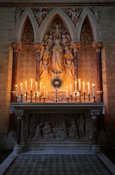 candles are lit in front of an ornate alter