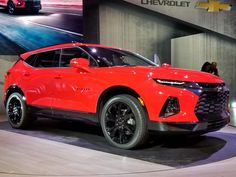 a red chevrolet suv on display at an auto show