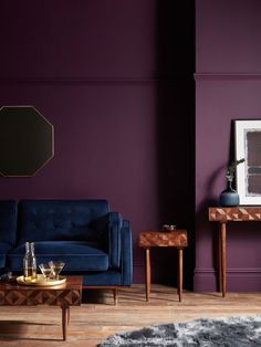 a living room with purple walls and wooden furniture in the corner, including a blue couch