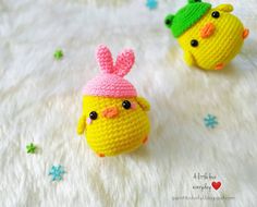 two small crocheted toys sitting on top of a white blanket