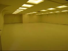 an empty room with lights on the ceiling and no one in it or someone else