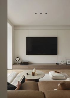 a living room filled with furniture and a flat screen tv mounted to the side of a wall