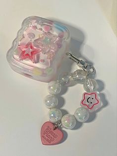 a pink and white heart shaped charm on a beaded bracelet with charms attached to it