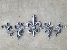 a metal fleur de lys design on the ground with no one around it