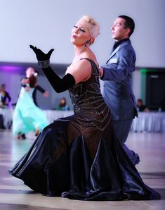 a man and woman in formal dress dancing