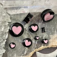 pink and black heart shaped buttons sitting on top of a piece of paper