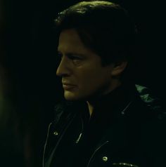 a close up of a person wearing a leather jacket and looking off to the side