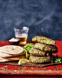 some food is stacked on top of each other with lemon wedges and lettuce