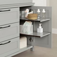 an open cabinet in a bathroom with soap, lotion and other items on the shelves