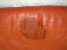 a brown leather couch that has been cleaned and is sitting on top of a white sheet