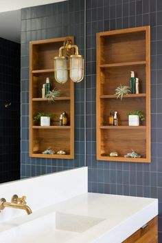 a bathroom with two wooden shelves above the sink and one on the wall next to it