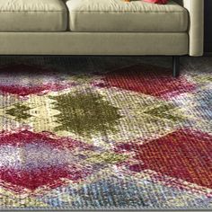 a living room scene with focus on the couch and colorful rug in the foreground