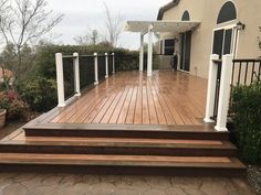 a wooden deck with white posts and railings