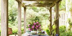 an outdoor dining area with table, chairs and potted flowers