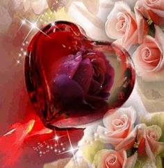 a red heart shaped glass vase filled with pink roses