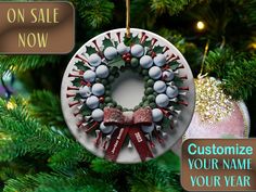 a christmas ornament with golf balls and bows hanging on a tree in front of a sale now sign